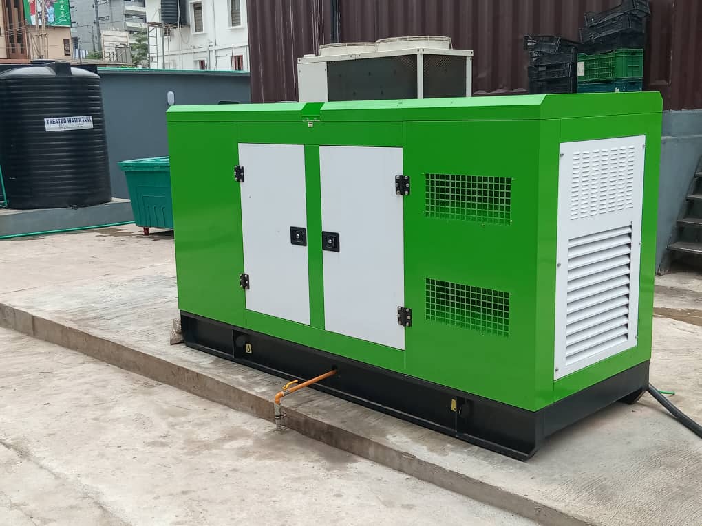 Gas generator installation at Nigerian commercial facility with technician performing maintenance